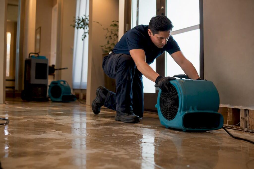 Technician operating drying equipment after burst pipe