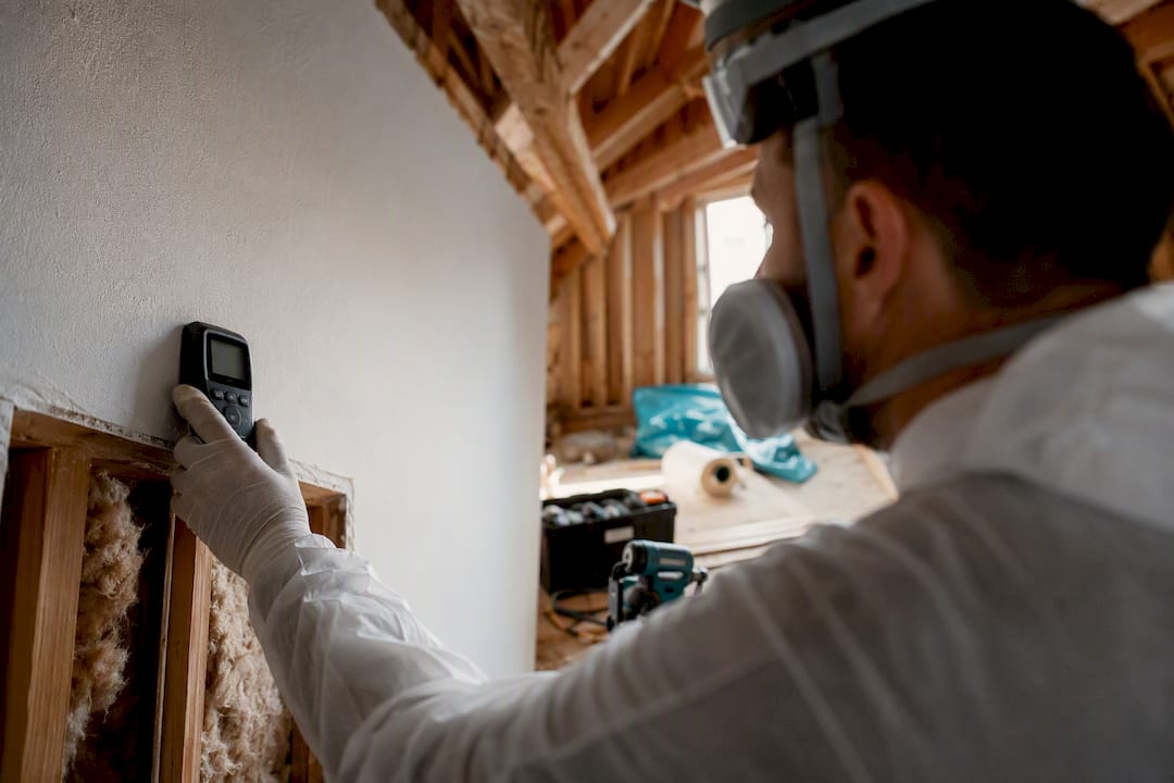 Technician measuring moisture in wall cavity
